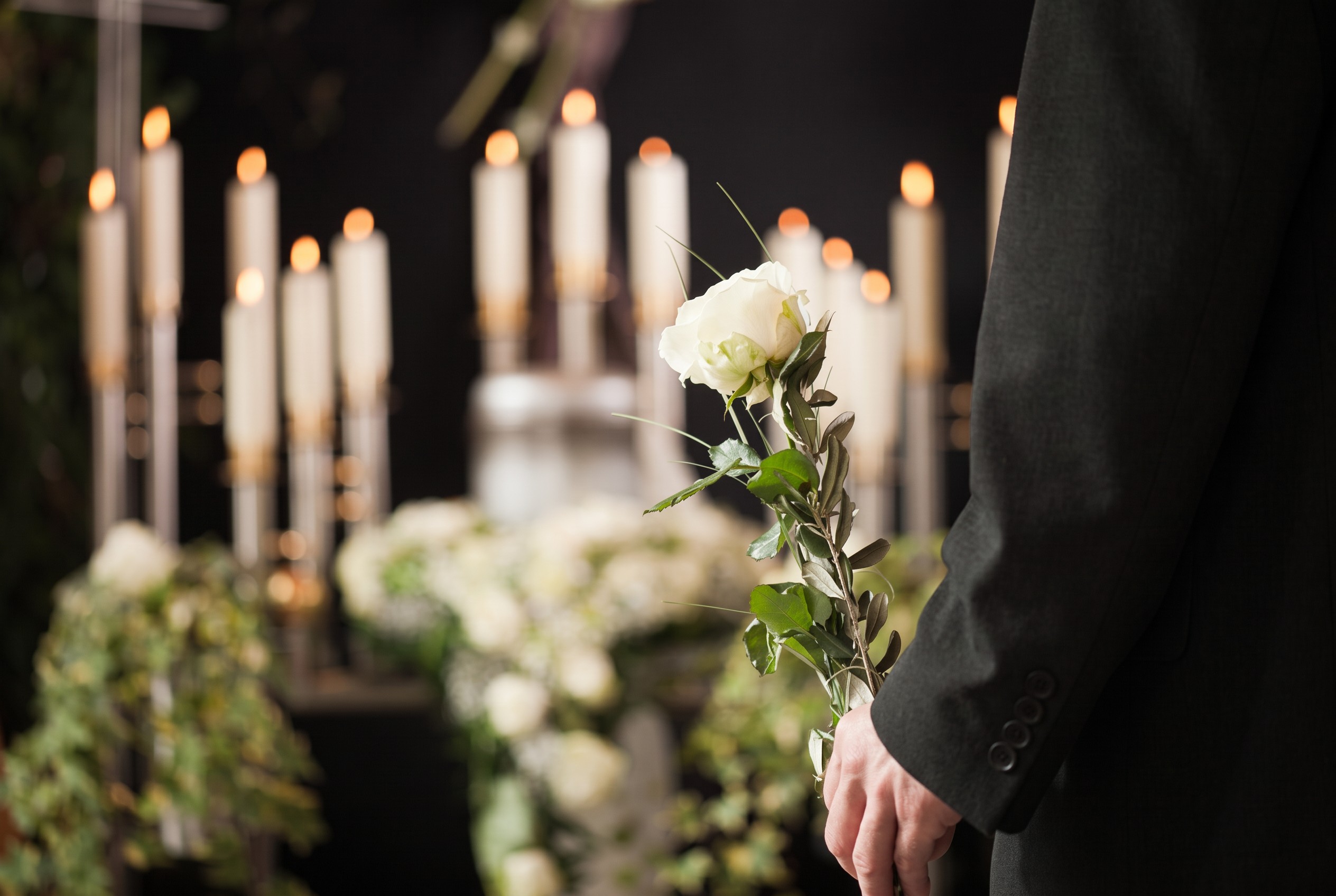 Homenagem com flores brancas e velas numa cerimónia de despedida